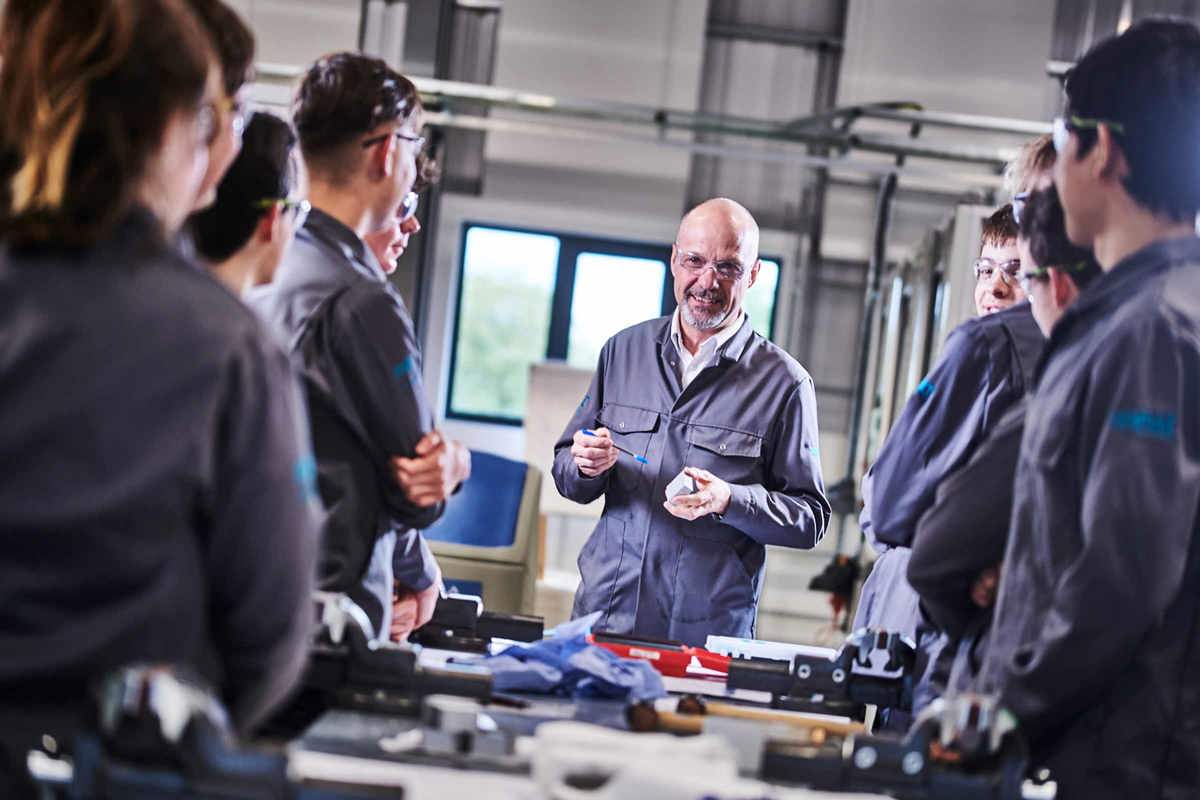 Group of apprentices gathered around an instructor in an MTC Training workshop