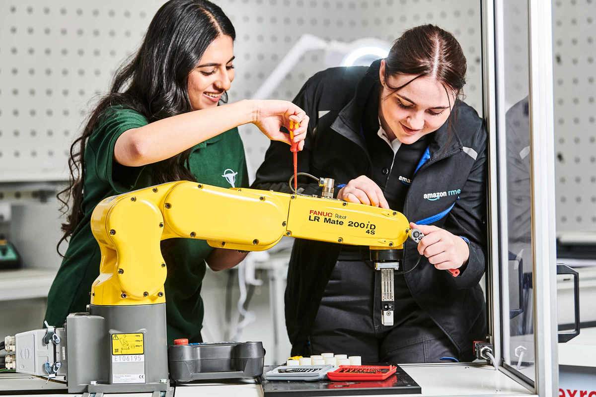 Two female apprentices working with a robotic arm at MTC Training